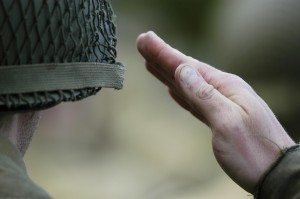 Un soldat en uniforme rétro olive drab et casque d'époque salue en faisant face à la caméra. Les soldats sont soumis à l'article 134 de l'UCMJ. Cette page traite des conséquences de la conduite sexuelle extraconjugale pour les membres du service