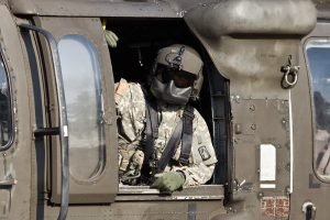 Helicopter Crew Chief leans out of a black hawk helicopter window