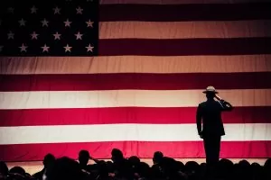 Drill Sergeant salutes in front of US flag