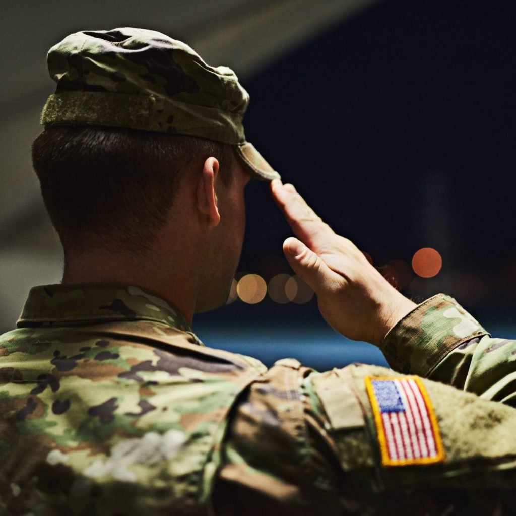 Officer saluting inside a hanger facing the outdoors at night; prevent adverse information in promotion file