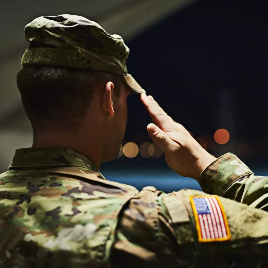 Officer saluting inside a hanger facing the outdoors at night; prevent adverse information in promotion file