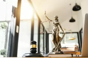 Photo of a statue of the lady holding the scales of justice with a judge's gavel at the bottom with sunlight coming into the window at top left; air force court-martial appeals process